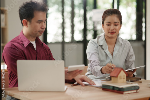 Male and female businessmen apply for a home loan in an office.