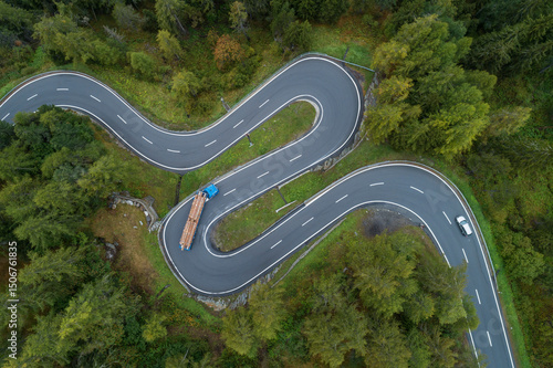 Drone view of logging truck driving along winding Maloja Pass road