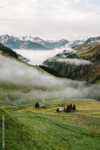 Sonnenaufgang in den Alpen mit Nebel im Tal und Schnee auf den Bergen