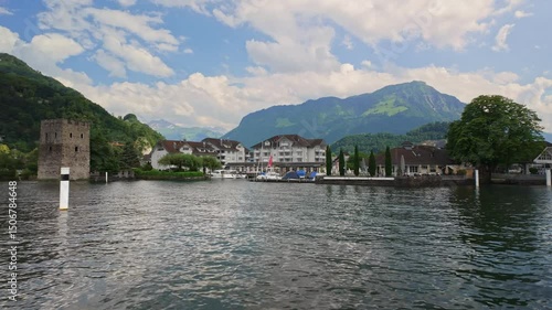 Waterfront view of Stansstad village with historic tower and marina on Lake Lucerne in Switzerland. 4K UHD video.