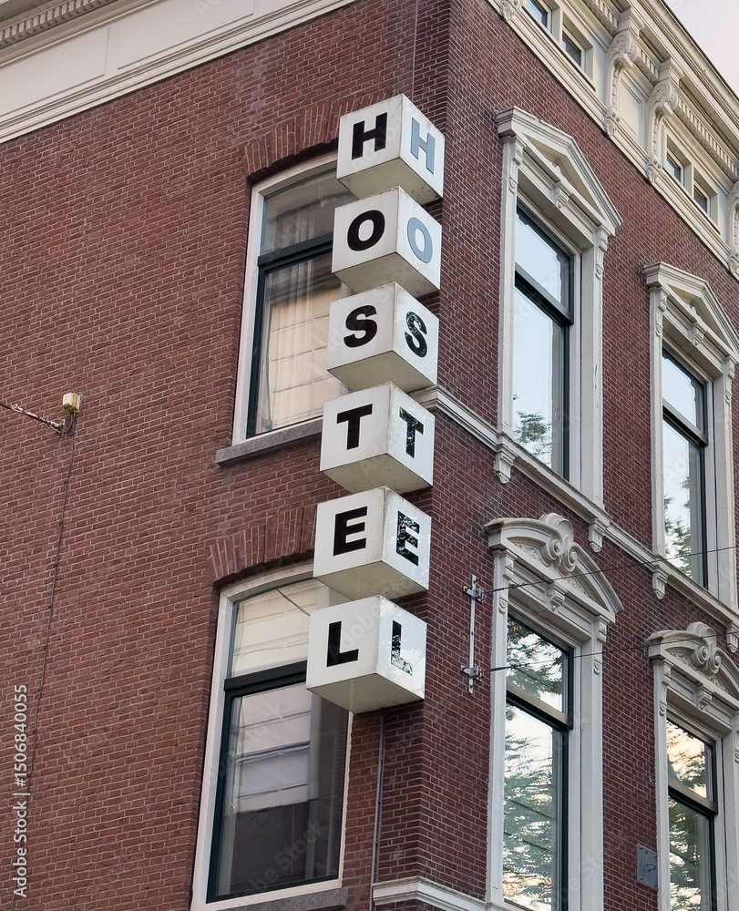 Obraz premium Hostel sign on brick wall building facade, Netherlands, Holland. Travel and accomodation