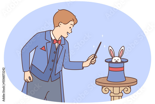 Man magician stands near hat in which rabbit is hiding in preparation for stunt