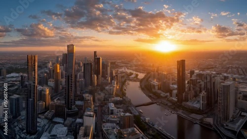 Aerial view of cityscape with skyscrapers and river at sunset with cloudy sky