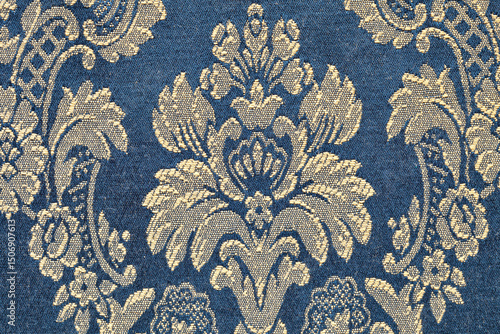 Photography particular of a strip of elegant damask silk fabric with golden floral pattern o