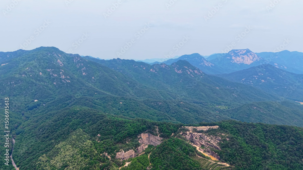 Fototapeta premium Aerial Drone Footage of Rugged Mountain Terrain and Lush Forest Slopes in Mungyeong, Korea – Scenic Nature and Rock Formations