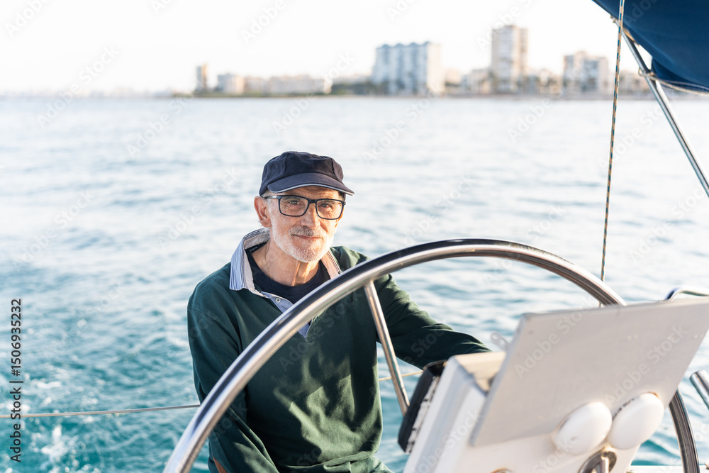 Naklejka premium Senior skipper steering sailboat on sunny day in ocean
