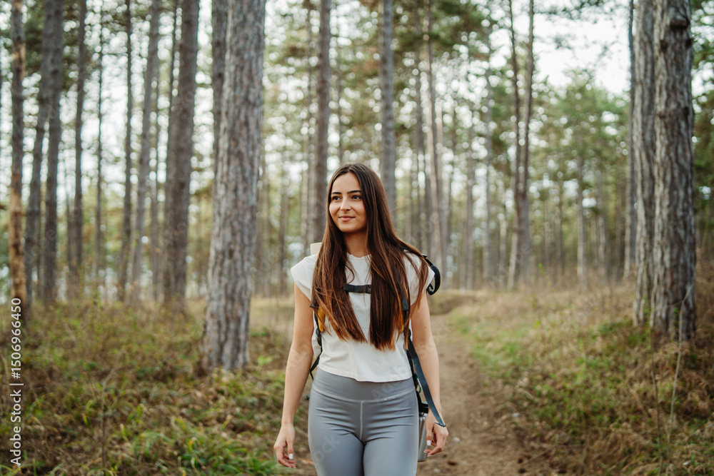 Young woman hike or trek and explore scenic forest with hiking sticks
Young woman hike or trek and explore scenic forest with hiking sticks