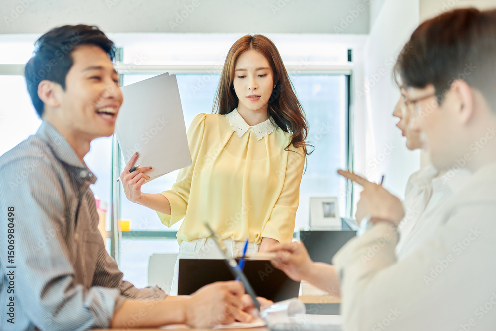 Young Asian Woman Leading Team Meeting with Colleagues in Modern Office Young Asian Woman Leading Team Meeting with Colleagues in Modern Office