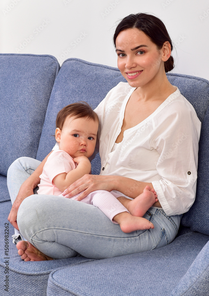 Mother and baby playing and smiling on the sofa. Happy family.Home interior. Mother and baby playing and smiling on the sofa. Happy family.Home interior.