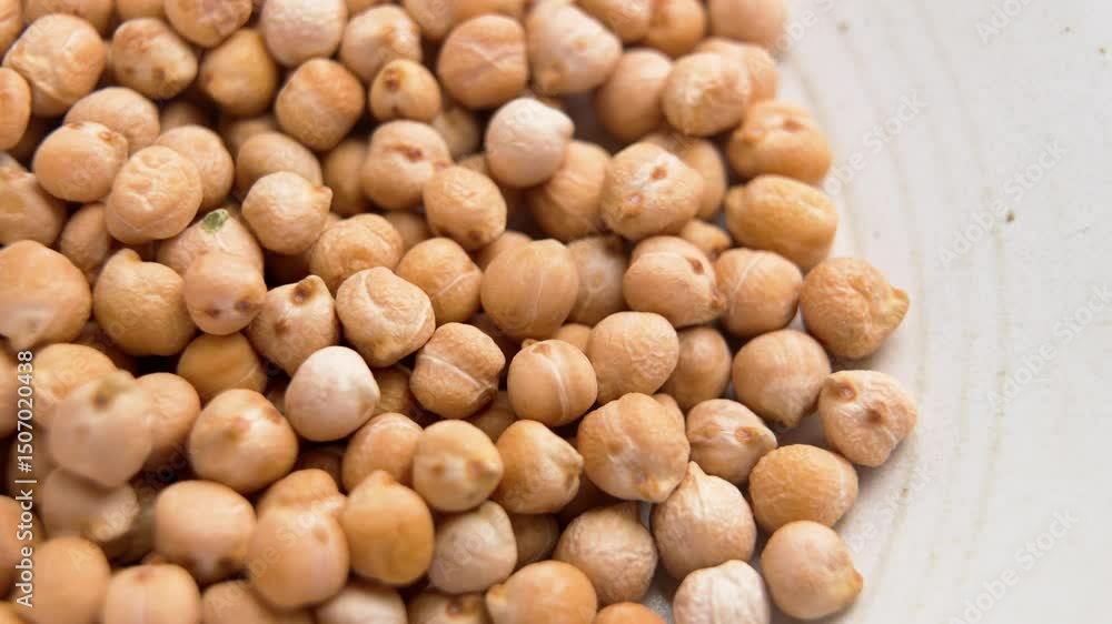 Dried uncooked chickpea ingredient in kitchen bowl. Legume family. Macro shot. Rotation Dried uncooked chickpea ingredient in kitchen bowl. Legume family. Macro shot. Rotation