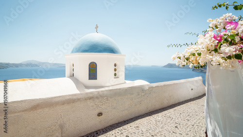 Fotografie Church dome and walls on the cliff of Santorini island, Aegean sea and Cyclades islands in the background