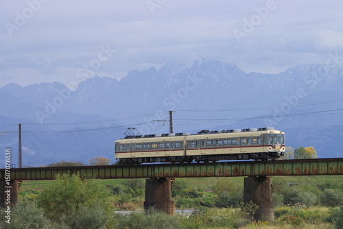 雄大な立山連峰を背景に鉄橋を渡る富山地鉄のモハ14760形電車_2023/11/5撮影