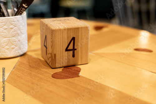 Wooden block displaying number four placed on restaurant table