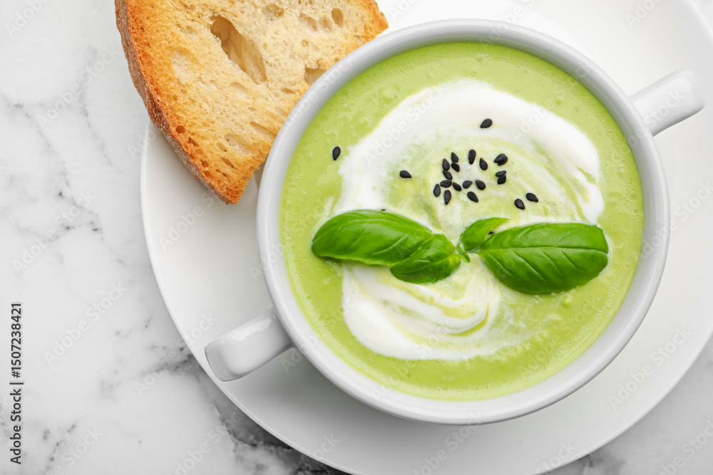 Tasty pea cream soup with basil served on white marble table, top view Tasty pea cream soup with basil served on white marble table, top view