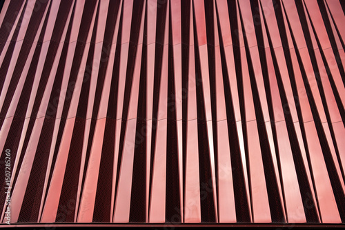 Detail of red vertical panels in an architectural facade, modern design and textures, ideal for contemporary architecture, urban design, and texture stock visuals.