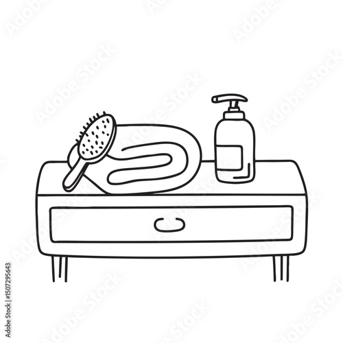 A towel lying beside a hairbrush on a vanity