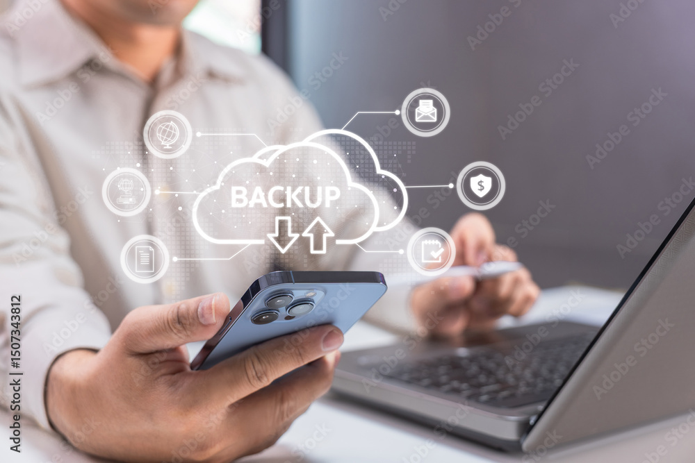 A person uses a smartphone and laptop for cloud backup, highlighting digital data protection and security. A person uses a smartphone and laptop for cloud backup, highlighting digital data protection and security.