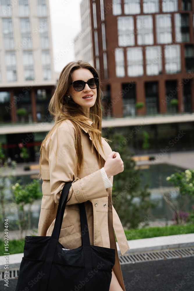 Fototapeta premium Young pretty beautiful woman in trench coat and sunglasses