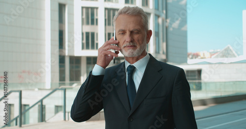 Professional mature lawyer talking on phone outdoors  client communication  business call