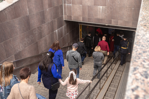 Foto A crowd of people descend into an underground passage to cross the road