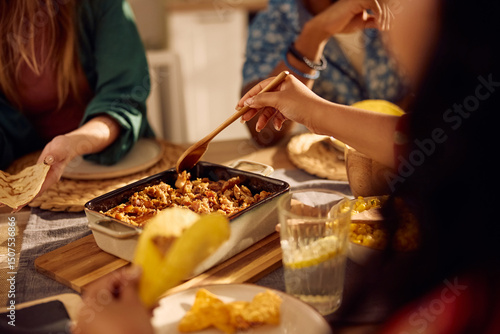 Close up of friends enjoying in Mexican food at dining table.