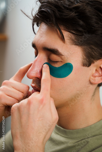 Fotografía Guy applies hydrogel moisturized eye patches on the face
