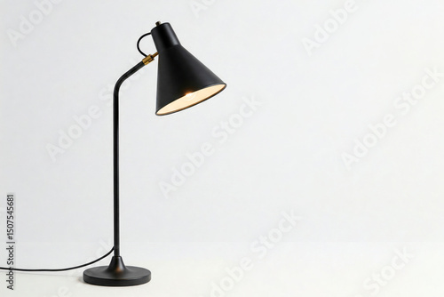 A black table lamp with a warm light on a light background. Space for text.