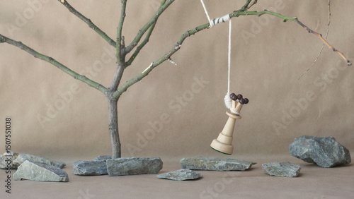 chess piece white queen hanging on noose among stones