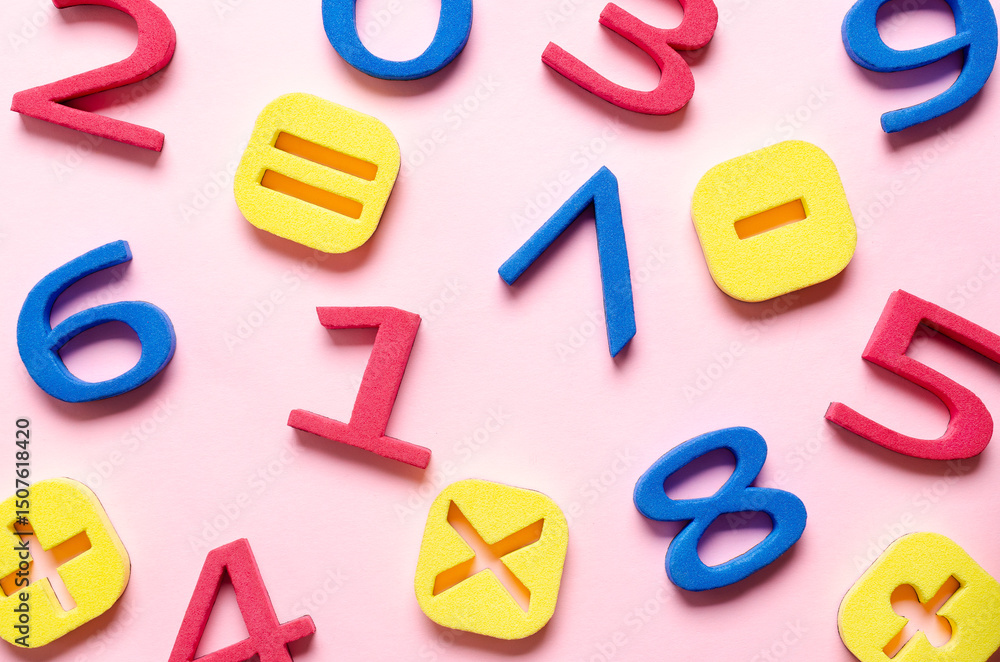 Fototapeta premium Colorful foam numbers and math symbols on pink background.