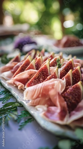 Fresh Figs and Prosciutto Arranged With Mint Leaves for a Gourmet Appetizer i...