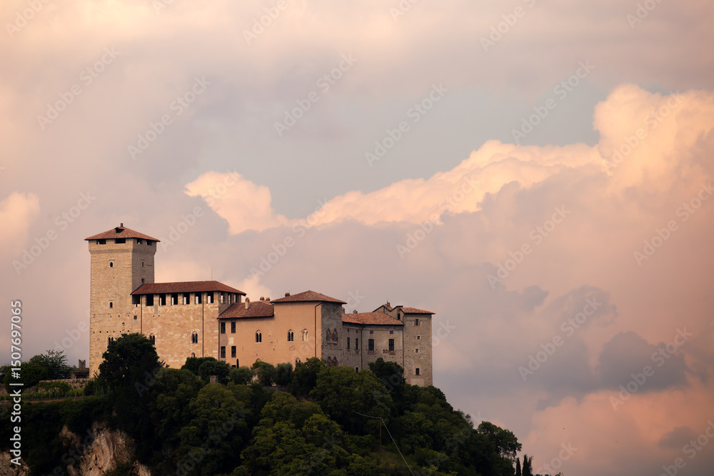 Fototapeta premium Historic Castle Surrounded by Lush Landscape Under a Dramatic Sky