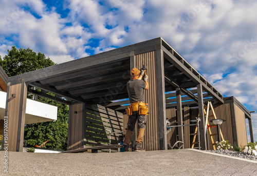 Cuadro en lienzo Craftsman Constructs a Modern Outdoor Structure on a Sunny Day Amid Fluffy Cloud