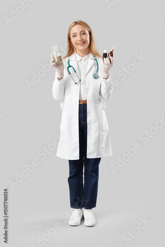 Obraz na plátně Female homeopathic doctor with herbs and remedy on light background