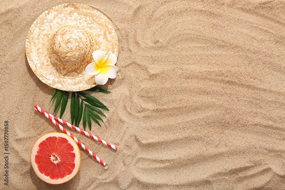 Fototapeta premium Summer composition with tropical leaf, grapefruit and wicker hat on sand as background