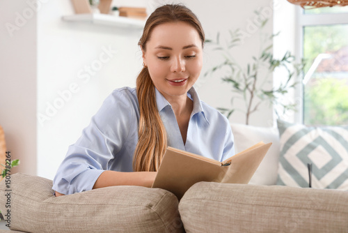 Smiling young woman reading...