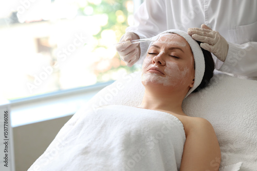 Beautician applying mask on...