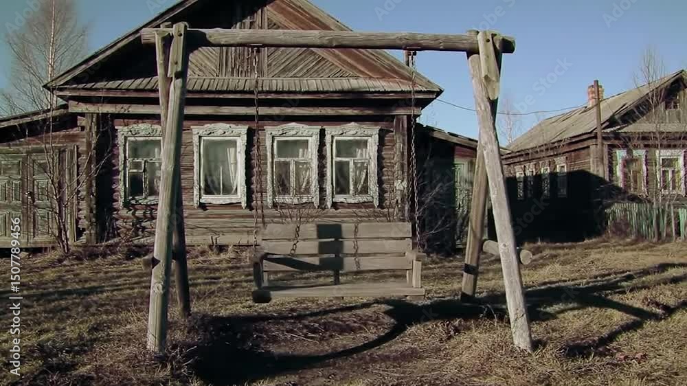 Rustic Wooden Swing Set in Front of Weathered Russian Village Houses Rustic Wooden Swing Set in Front of Weathered Russian Village Houses