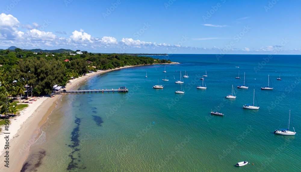 Obraz premium Serene Beach with Calm Azure Waters and Sailboats Under Blue Sky