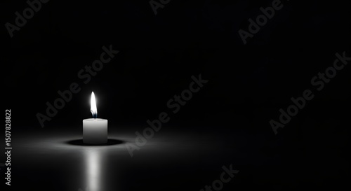 Burning candle glowing in the dark with warm light