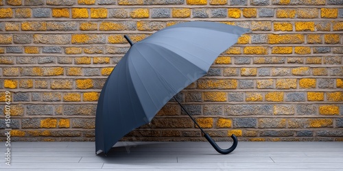 A folded umbrella leaning against a brick wall after use