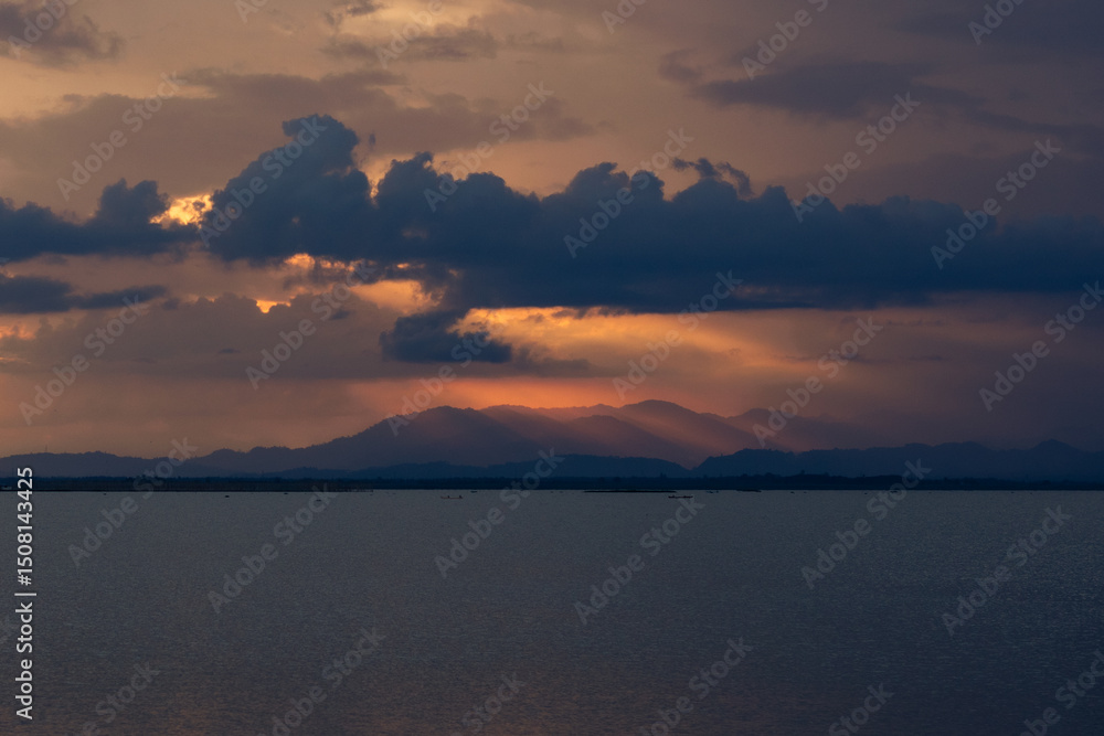 Fototapeta premium Sunset Over Mountains and Calm Water