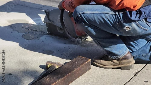 Workers cutting cement floor with concrete saw