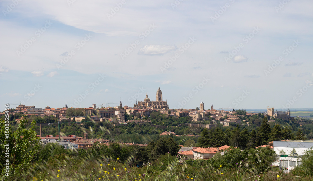 Fototapeta premium Segovia Cathedral rising above the cityscape under cloudy sky in Spring