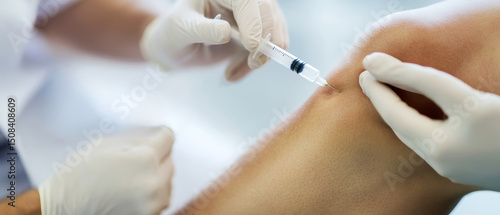 Doctor administering injection on patient's knee with modern equipment in a clinical setting