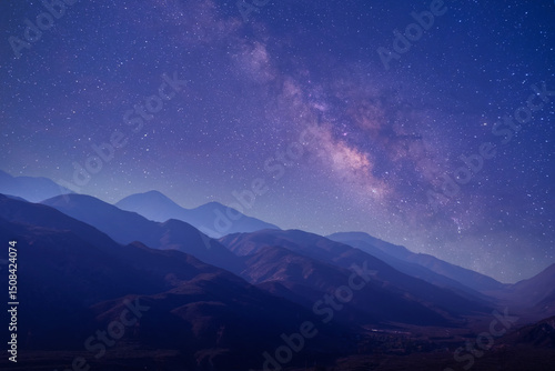 Starry sky over mountains at night with Milky Way