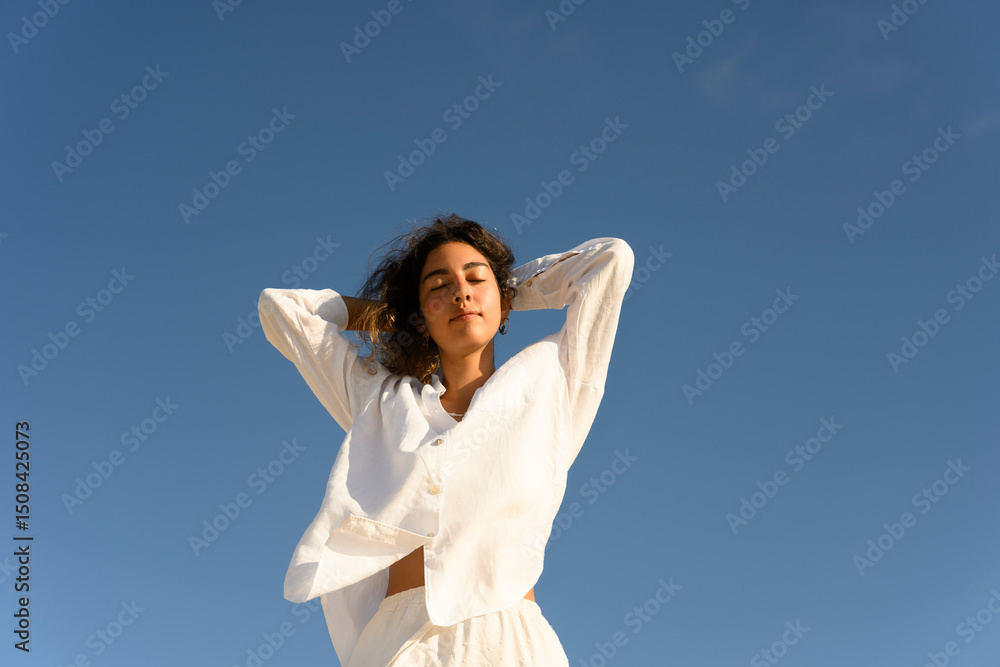 Confident woman with long hair enjoying a sunny day outdoors Confident woman with long hair enjoying a sunny day outdoors