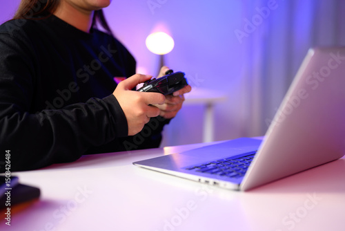Schilderij op canvas Close up of gamer holding a console controller while playing on a laptop