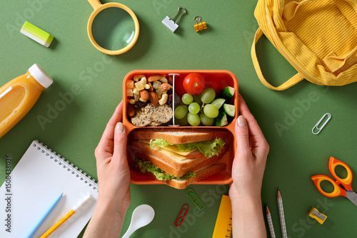 Healthy school lunch box: nutritious meal with sandwich, fruits, and nuts for kids.