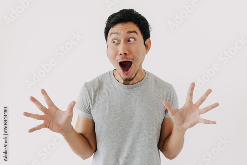 Shocked Asian man with open mouth and hands spread in disbelief