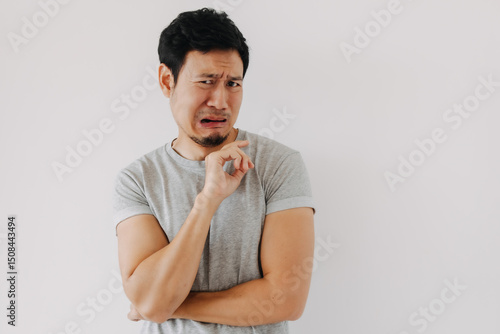 Bild auf Leinwand Asian man making disgusted face with curled lip and finger gesture
